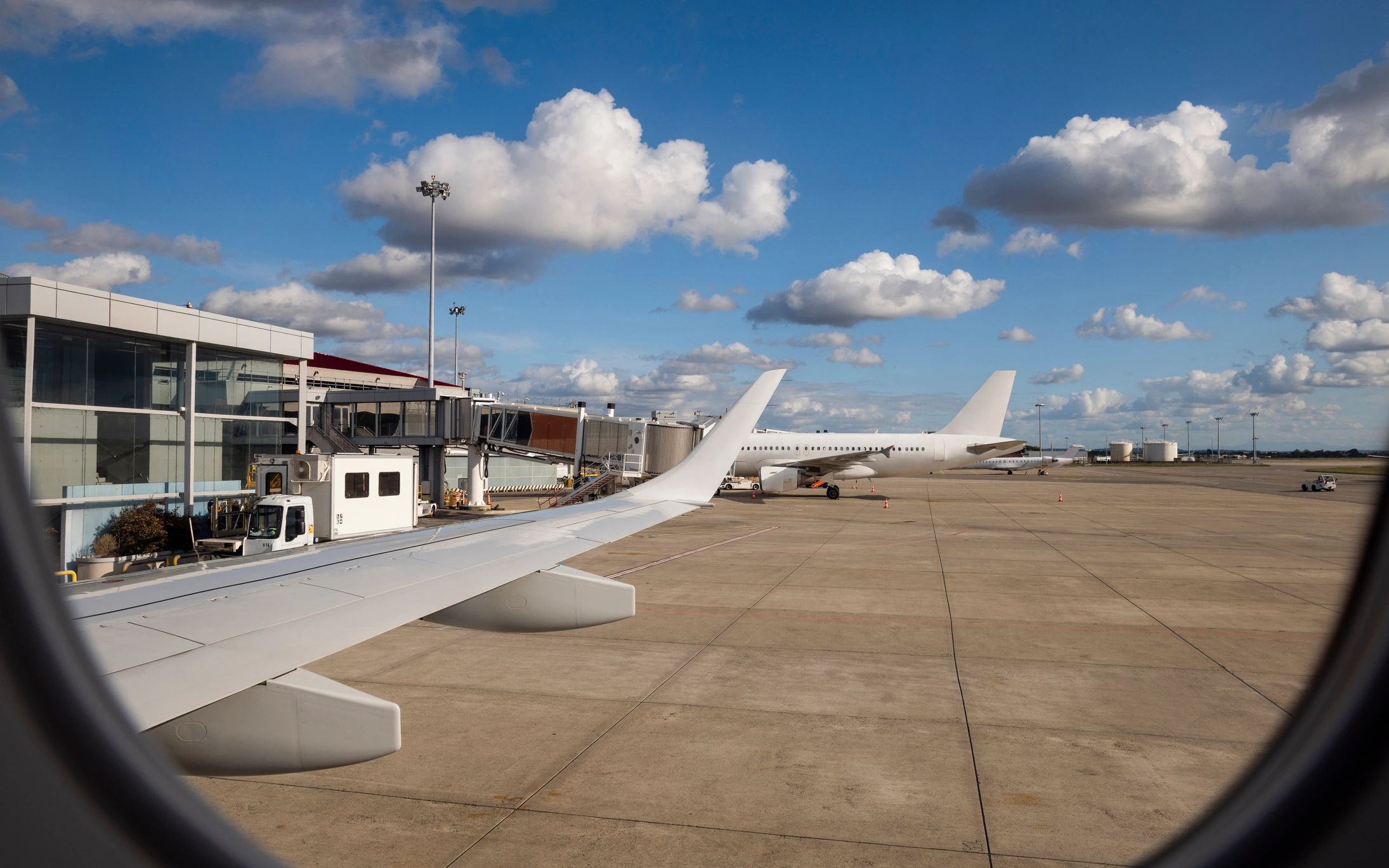 Commercial airliner taxiing at an airport with terminal activity in view
